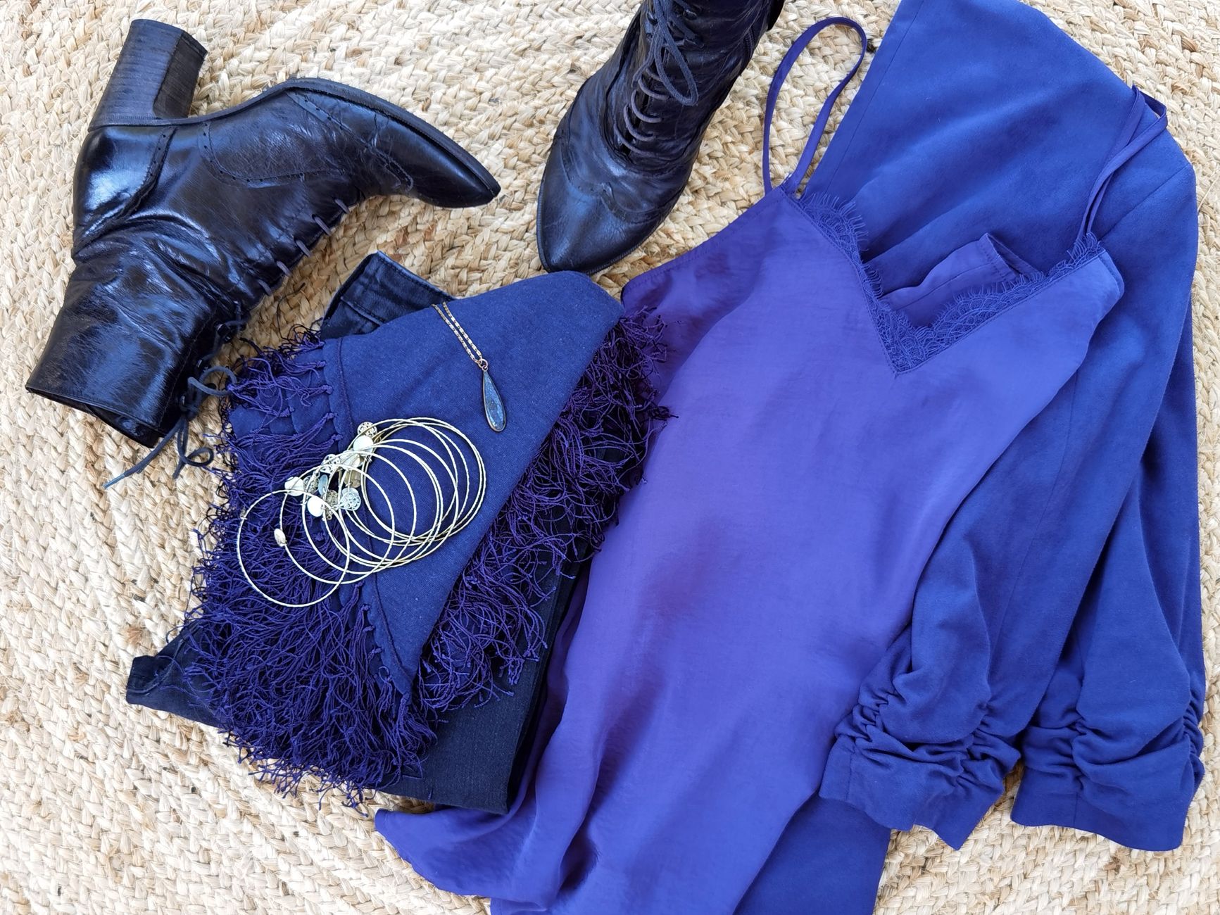 Stylish flat lay featuring black leather boots paired with a chic blue dress and stylish jewelry.